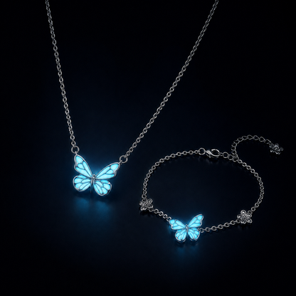 The butterfly necklace and bracelet glowing aqua in the dark
